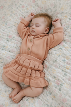 Baby in Peach Knit Ruffle Romper - Another Angle