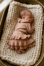Newborn in knitted ruffle dress, alternate pose